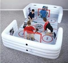 an inflatable ice rink with hockey players and goalies on the floor,