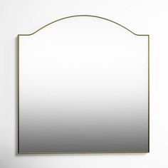 a mirror hanging on the wall in front of a white wall with a gold frame