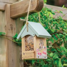 a bird feeder hanging from a wooden fence