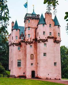 an old pink castle is shown in the park