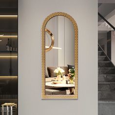 a living room with a large mirror on the wall and a table in front of it