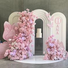 pink flowers on display in front of a white arch with the word hanaa written on it