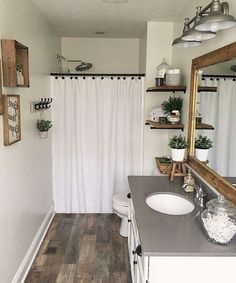 a bathroom with wood floors and white walls