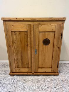 a wooden cabinet sitting on top of a tiled floor