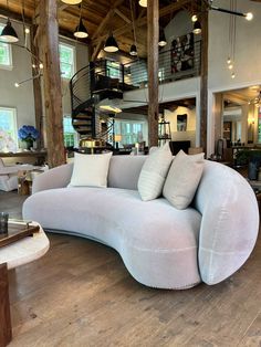 a large curved couch sitting on top of a hard wood floor