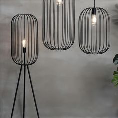 three black metal cage lamps with one light on each side and the other turned on