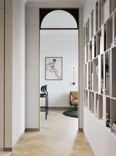 an open door leading to a living room with bookshelves and chairs in it