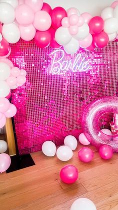 pink and white balloons are on the floor next to a sign that says, barbie