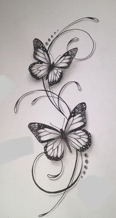 two butterflies with swirls and dots on white paper