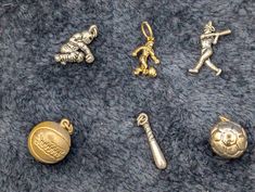 several different types of metal items laying on a gray surface, including a keychain