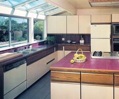 a kitchen with an oven, sink, dishwasher and window in the background