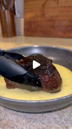 a steak is being prepared in a pan