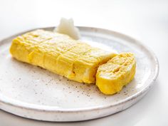 a white plate topped with an omelet on top of a table