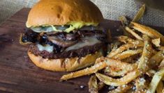 a hamburger and french fries on a cutting board