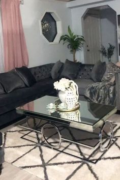 a living room filled with furniture and a glass table in front of the couches