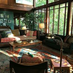 a living room filled with lots of furniture next to a window covered in sunbeams