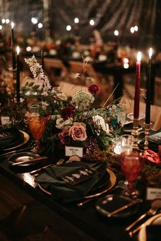 the table is set with candles, plates and place cards for guests to sit at