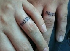 two people with tattoos on their fingers holding hands