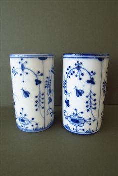 two blue and white cups sitting next to each other