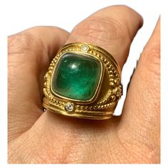 Large, ornate Byzantine style cushion shaped emerald green tourmaline, diamond and 18K yellow gold statement ring. High quality, impressive ring very similar to the Elizabeth Gage Templar ring- this ring has been sized and the signature may have been removed in the process. The cushion shaped cabochon tourmaline measures 12.5mm by 12.5mm by 8.2mm, approximately 10.6 TCW, beautiful emerald green color with natural attractive inclusions, surrounded by collet-set round diamonds, gold bead details, crescent moon with gold bead details motif at the top and base of ring setting, textured and highly polished gold finishes. A stunning statement ring. Size 7US Very good condition, sizing to the back of the ring with slight waviness Ring dimensions: 21mm by 21mm Marks: 18K Byzantine Rings, Green Tourmaline Ring, Gold Statement Ring, Jewelry Fashion Trends, Cabochon Ring, 18k Yellow Gold Ring, Tourmaline Ring, Yellow Gold Ring, Green Tourmaline