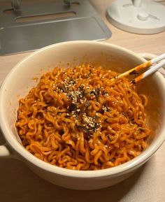 a bowl of noodles with chopsticks in it