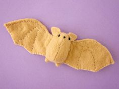 a stuffed toy bat on a purple background