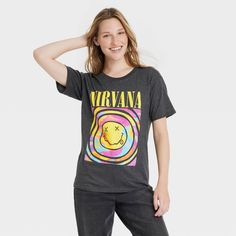 a woman in black pants and a nirvana t - shirt is posing for the camera