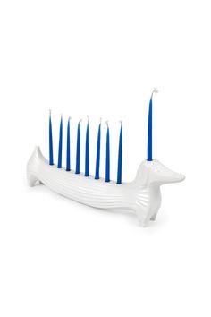 a white and blue toothbrush holder with six blue candles in the shape of a dolphin