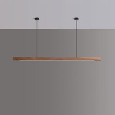 three lights hanging from the ceiling above a wooden shelf with two black lamps on it