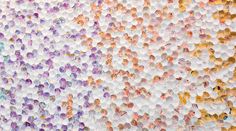 an abstract painting made up of many different colored circles and dots on white paper with yellow, pink, blue, purple, and orange colors