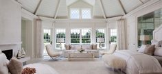 a living room filled with white furniture and windows