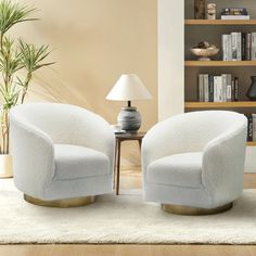 two white chairs sitting next to each other in a living room