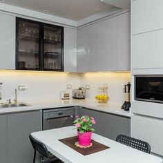 a kitchen with white cabinets and gray counter tops