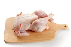 raw chicken on wooden cutting board with white background