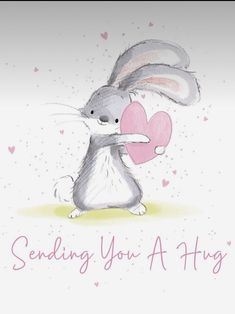 a rabbit holding a heart with the words sending you a hug