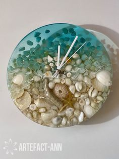 a clock made out of sea shells and sand