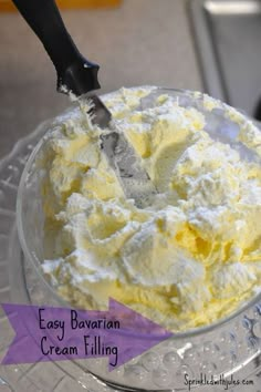 a bowl filled with ice cream sitting on top of a glass table next to a knife