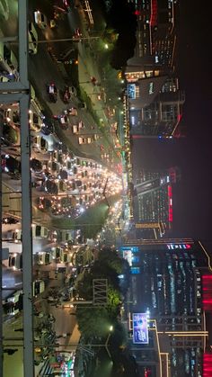 a city street filled with lots of traffic next to tall skyscrapers at night time