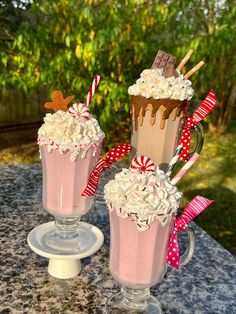 two glasses filled with hot chocolate and marshmallows on top of a table