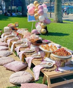 a table set up for a party with balloons and desserts on the tables in front of it