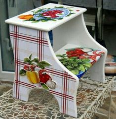 two chairs that are sitting next to each other on a metal stand with flowers and fruits painted on them