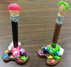 two toy toothbrushes sitting on top of each other in front of a wooden table