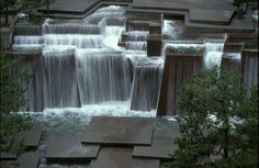 the water is flowing down the side of the waterfall