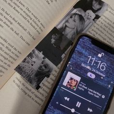 an open book with pictures on it and a cell phone sitting next to the opened book