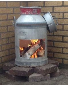 a large metal pot sitting on top of a fire place next to a brick wall