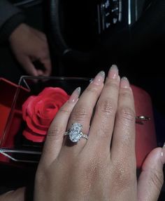 a woman's hand with a ring on it and a rose in her lap