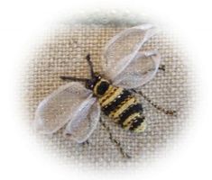 two bees sitting next to each other on a piece of cloth