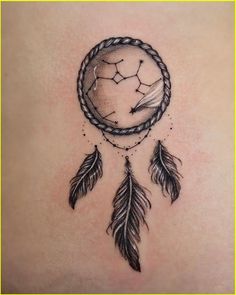 the back of a woman's stomach with a dream catcher tattoo design on it