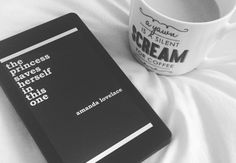 a book and coffee cup sitting on a bed