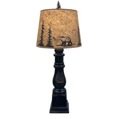 a lamp that has a bear on it with trees in the background and a brown shade